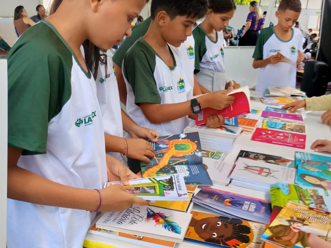 Jovens participantes manuseando livros e materiais literários