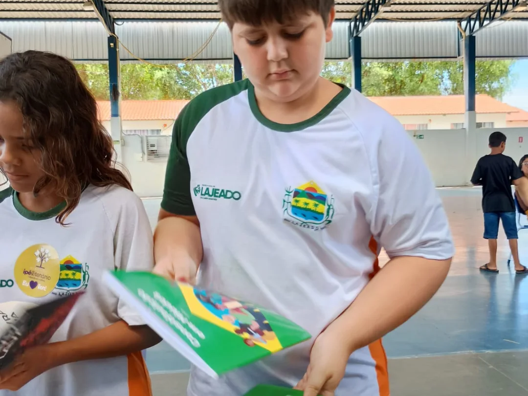 Participantes com materiais do projeto em espaço comunitário